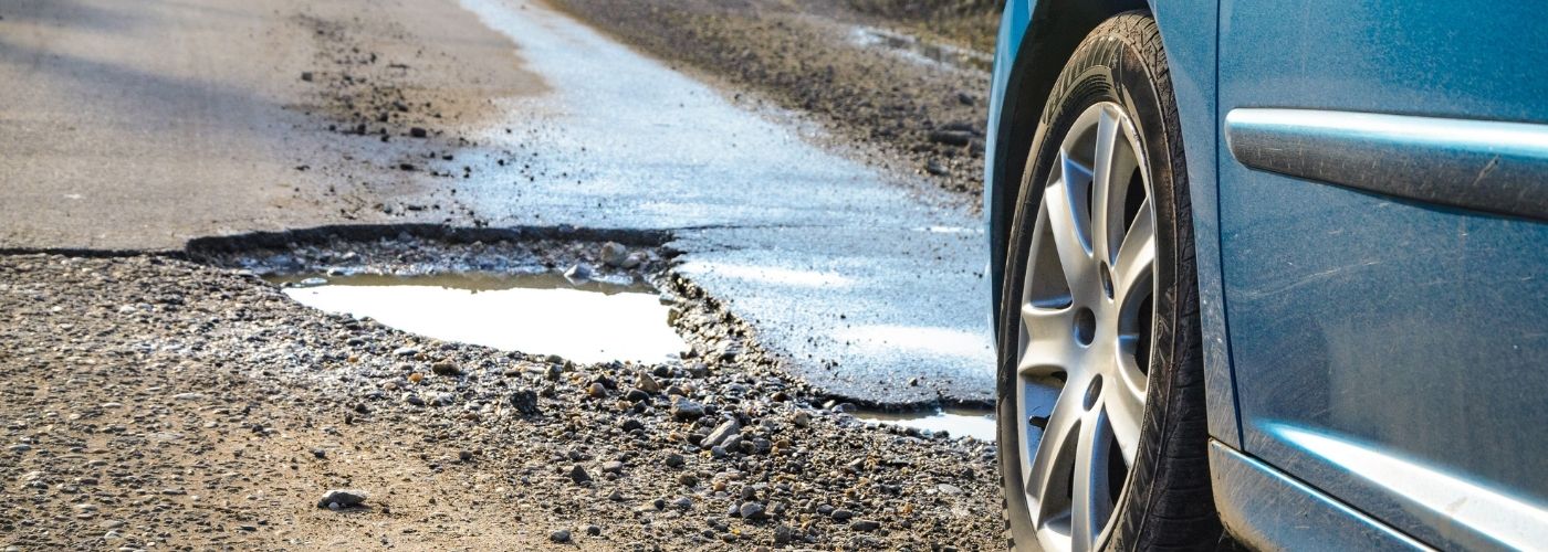 Car driving on the road. A pothole on the road.