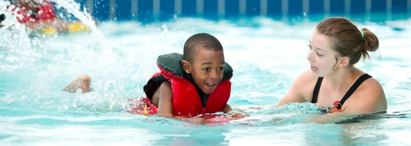 Kid taking swimming lessons.